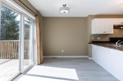 Dining area featuring light wood-finish flooring, a contemporary ceiling light fixture, and direct access to an outdoor deck - 