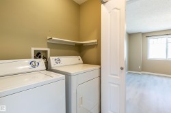 Dedicated laundry area featuring a washer and dryer, an overhead corner shelf, and neutral wall paint - 