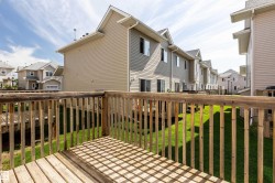 Wooden deck with baluster railings and a view of a grassy yard - 