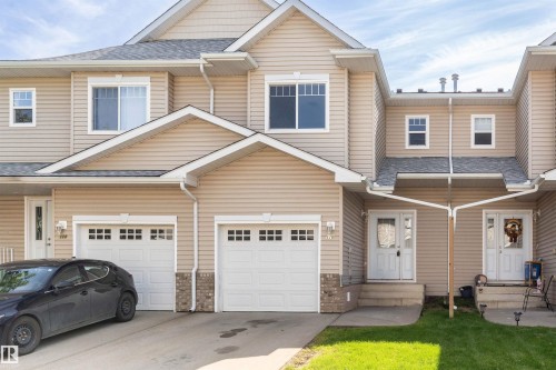 Duplex exterior featuring light-toned siding, white trim, gabled roofs, and an asphalt shingle roof - #116 5001 62 St, Beaumont, AB - Outdoor With Facade