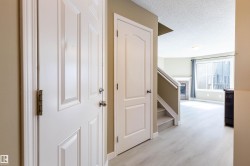 Entryway with light wood-finish flooring, white paneled doors, and neutral wall tones - 