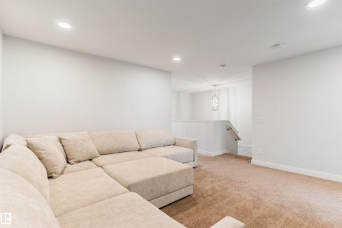 Carpeted bonus room featuring recessed lighting and a contemporary pendant light fixture - 6003 Edmonds Place Nw, Edmonton, AB - Indoor