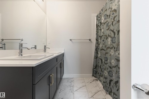 Bathroom vanity featuring dual rectangular sinks, chrome faucets, and white countertops - 6003 Edmonds Place Nw, Edmonton, AB - Indoor Photo Showing Bathroom