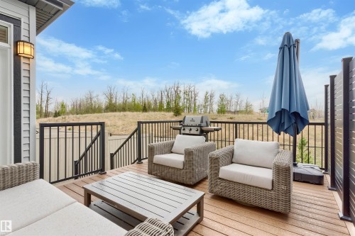 Spacious outdoor deck featuring wood-finish flooring, black metal railings, and privacy screens - 6003 Edmonds Place Nw, Edmonton, AB - Outdoor With Deck Patio Veranda With Exterior