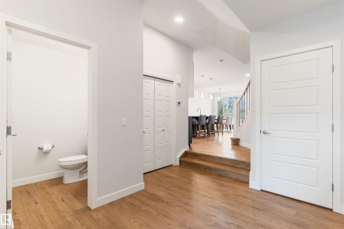 Main-level powder room featuring a white toilet and toilet paper holder - 6003 Edmonds Place Nw, Edmonton, AB - Indoor Photo Showing Other Room