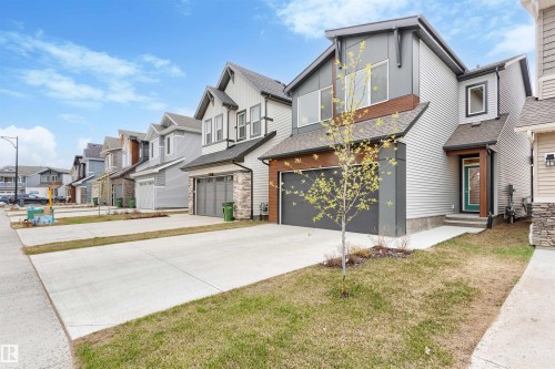 Contemporary two-story exterior featuring a grey and white color palette, multiple windows, an attached garage, a covered front entryway, and a concrete driveway - 6003 Edmonds Place Nw, Edmonton, AB - Outdoor With Facade