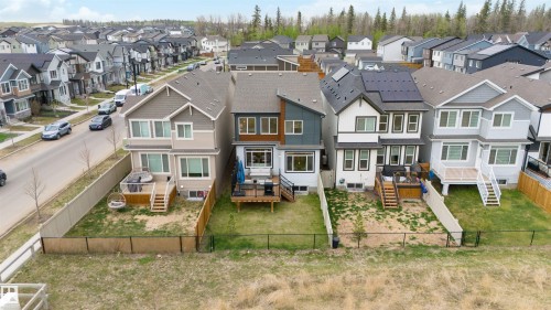 Modern residential architecture featuring a mix of siding styles and rooflines, private rear decks, and fenced backyards - 6003 Edmonds Place Nw, Edmonton, AB - Outdoor With Facade