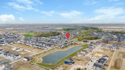 Aerial perspective showcasing a residential community with a central body of water - 6003 Edmonds Place Nw, Edmonton, AB - Outdoor With View