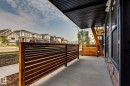 Covered concrete patio with slatted wood privacy screen, dark wood-finish ceiling, and exposed wood structural beam - 16231 19 Avenue, Edmonton, AB  - Outdoor With Exterior 