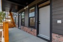Contemporary exterior featuring dark horizontal siding, brick accents, and a covered concrete porch - 16231 19 Avenue, Edmonton, AB  - Outdoor With Exterior 