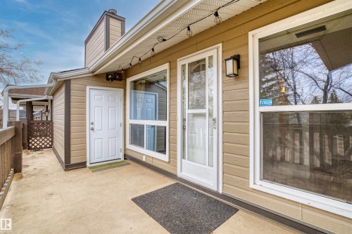 Exterior patio with concrete surface, tan siding, and white trim - 1116 Saddleback Road, Edmonton, AB - Outdoor With Exterior