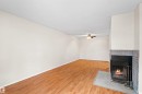 Living area featuring a fireplace with a dark stone facade and a tile hearth - 1116 Saddleback Road, Edmonton, AB  - Indoor Photo Showing Other Room With Fireplace 