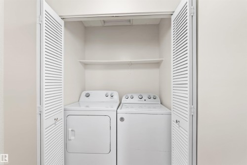 Dedicated laundry area featuring bi-fold louvered doors, white appliances, and an overhead storage shelf - 1116 Saddleback Road, Edmonton, AB - Indoor Photo Showing Laundry Room