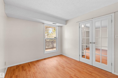 Room featuring wood-finish flooring, a window offering exterior exposure, and white walls - 1116 Saddleback Road, Edmonton, AB - Indoor Photo Showing Other Room