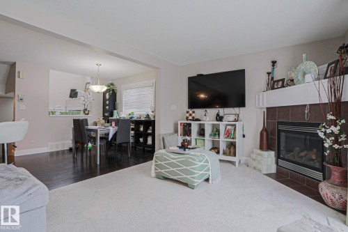 Living area featuring a fireplace with a tiled surround and white mantel - 1621 64 Street, Edmonton, AB - Indoor Photo Showing Living Room With Fireplace