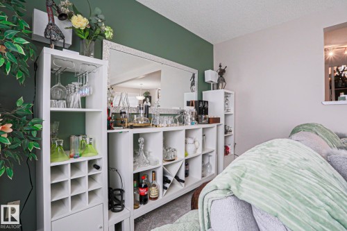 Built-in shelving unit featuring wine storage, stemware racks, and a mirrored accent wall - 1621 64 Street, Edmonton, AB - Indoor Photo Showing Bedroom