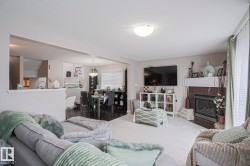 Carpeted living area featuring a built-in fireplace with a tile surround and a mantel - 