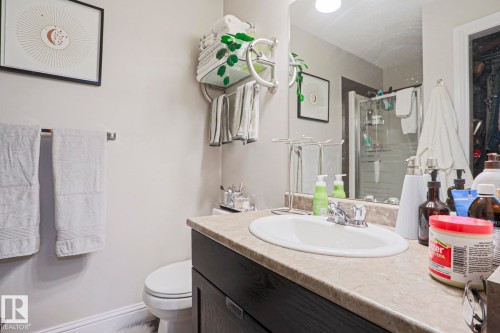 Bathroom featuring a vanity with an integrated sink, a light-toned countertop, and dark wood-finish cabinetry - 1621 64 Street, Edmonton, AB - Indoor Photo Showing Bathroom