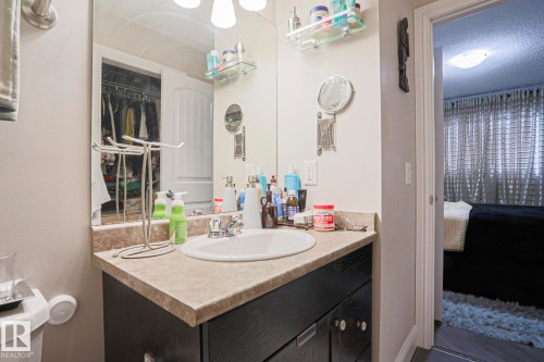 Bathroom vanity featuring a single basin, laminate countertop, and dark wood-finish cabinetry - 1621 64 Street, Edmonton, AB - Indoor Photo Showing Bathroom