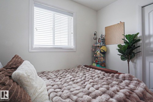 White interior walls with a single window featuring horizontal blinds - 1621 64 Street, Edmonton, AB - Indoor Photo Showing Bedroom