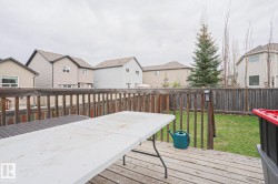 Expansive wood deck with a full wood railing, overlooking a green lawn - 