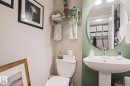 Pedestal sink with chrome faucet and circular mirror - 1621 64 Street, Edmonton, AB  - Indoor Photo Showing Bathroom 
