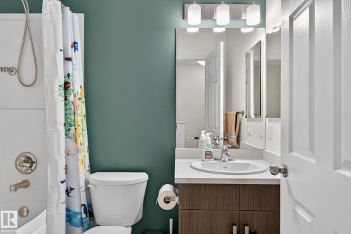 Bathroom featuring a single vanity with a white countertop, undermount sink, and a mirrored medicine cabinet - 16 7503 Getty Gate, Edmonton, AB - Indoor Photo Showing Bathroom