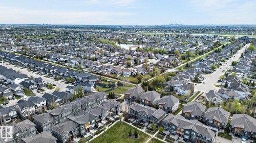 Expansive aerial perspective showcasing a residential development with individual homes and multi-unit townhome structures - 16 7503 Getty Gate, Edmonton, AB - Outdoor With View