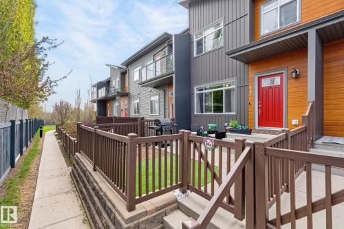Contemporary exterior architecture featuring mixed siding in gray and wood tones - 16 7503 Getty Gate, Edmonton, AB - Outdoor With Exterior