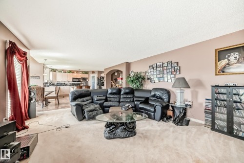 Open-concept living area featuring light-toned carpeting and neutral wall paint - 5107 200 Street, Edmonton, AB - Indoor Photo Showing Living Room