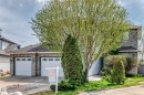 Two-story residence featuring a brick facade and a triple car garage. - 5107 200 Street, Edmonton, AB  - Outdoor 