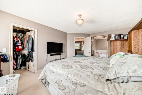 Carpeted bedroom featuring a flush-mount ceiling light fixture and neutral wall paint - 5107 200 Street, Edmonton, AB - Indoor Photo Showing Bedroom