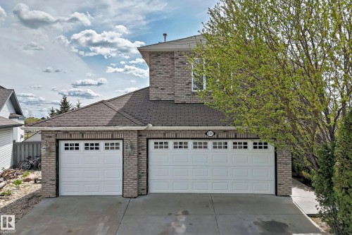 Brick exterior featuring a two-car garage and an additional single-car garage with paneling and window inserts - 5107 200 Street, Edmonton, AB - Outdoor