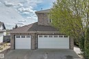 Brick exterior featuring a two-car garage and an additional single-car garage with paneling and window inserts - 5107 200 Street, Edmonton, AB  - Outdoor 