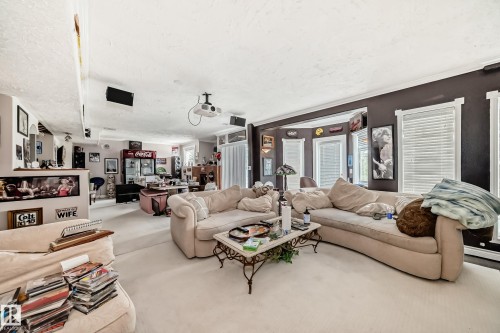 Expansive entertainment area featuring recessed lighting, a ceiling-mounted projector, and integrated ceiling speakers - 5107 200 Street, Edmonton, AB - Indoor Photo Showing Living Room