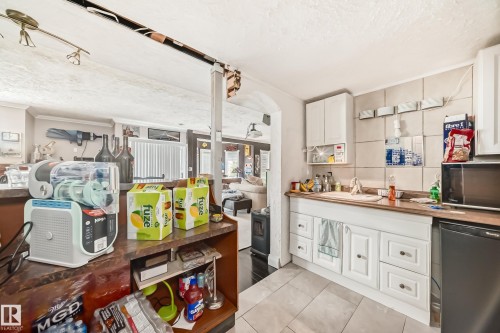 Kitchen area featuring white cabinetry, a neutral-toned tile backsplash. - 5107 200 Street, Edmonton, AB - Indoor