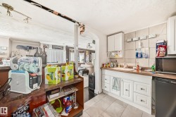 Kitchen area featuring white cabinetry, a neutral-toned tile backsplash. - 