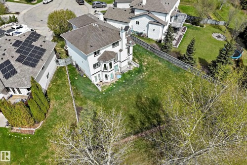 Spacious rear yard featuring an expansive lawn, mature trees, and a privacy fence - 5107 200 Street, Edmonton, AB - Outdoor With View