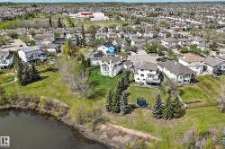 Expansive property featuring a waterfront setting, mature evergreen trees, and a spacious green lawn - 