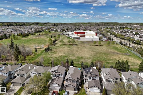 Aerial perspective showcasing a residential neighborhood with detached homes, expansive green spaces. - 5107 200 Street, Edmonton, AB - Outdoor With View
