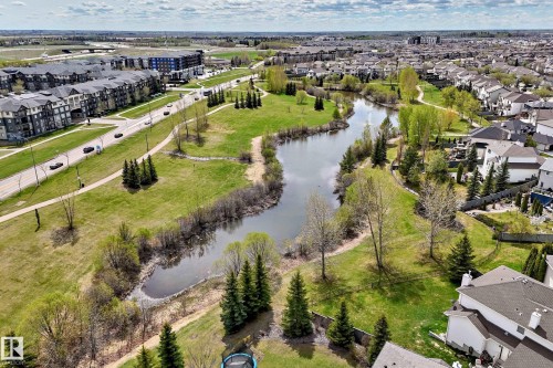 Expansive urban landscape featuring a central waterway, surrounding green spaces, paved pathways, and mature trees - 5107 200 Street, Edmonton, AB - Outdoor With View
