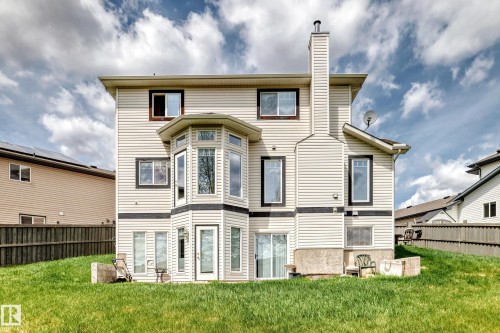 Rear exterior featuring light-colored siding, a multi-story bay window, and a prominent chimney - 5107 200 Street, Edmonton, AB - Outdoor
