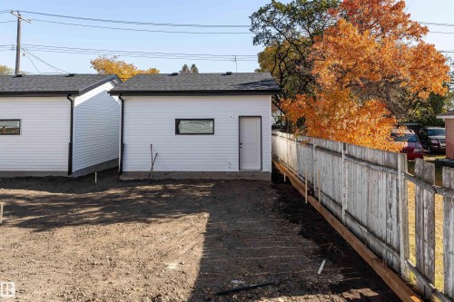Detached white-sided outbuilding with a black shingled roof, a rectangular window with dark trim, and a white entry door - 12031 124 Street Nw, Edmonton, AB - Outdoor With Exterior