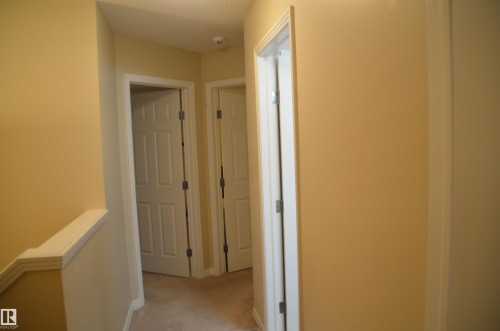 Upper-level corridor with carpeted flooring, neutral wall tones, and white trim - 1412 152, Edmonton, AB - Indoor Photo Showing Other Room