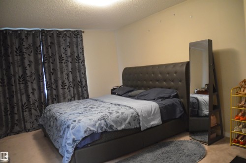 Bedroom featuring neutral wall color, light-toned carpeting, and a ceiling-mounted light fixture - 1412 152, Edmonton, AB - Indoor Photo Showing Bedroom