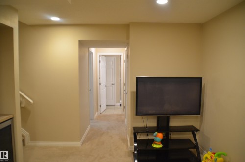 Recessed lighting illuminates the neutral wall colors and carpeted flooring - 1412 152, Edmonton, AB - Indoor Photo Showing Other Room