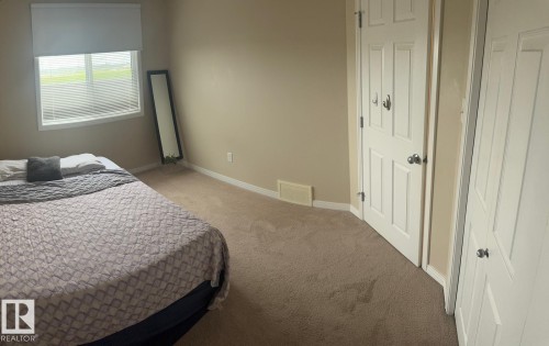 Room featuring a window with horizontal blinds, neutral wall paint, and light brown carpeting - 1412 152, Edmonton, AB 