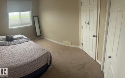 Room featuring a window with horizontal blinds, neutral wall paint, and light brown carpeting - 