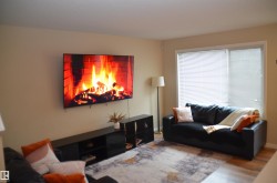 Living area featuring light beige walls and wood-finish flooring - 