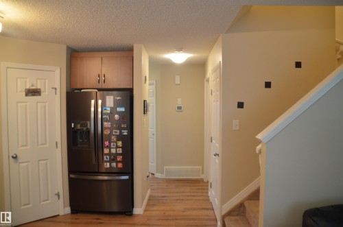 Wood-finish flooring throughout, complemented by light neutral wall tones and white trim - 1412 152, Edmonton, AB - Indoor Photo Showing Other Room
